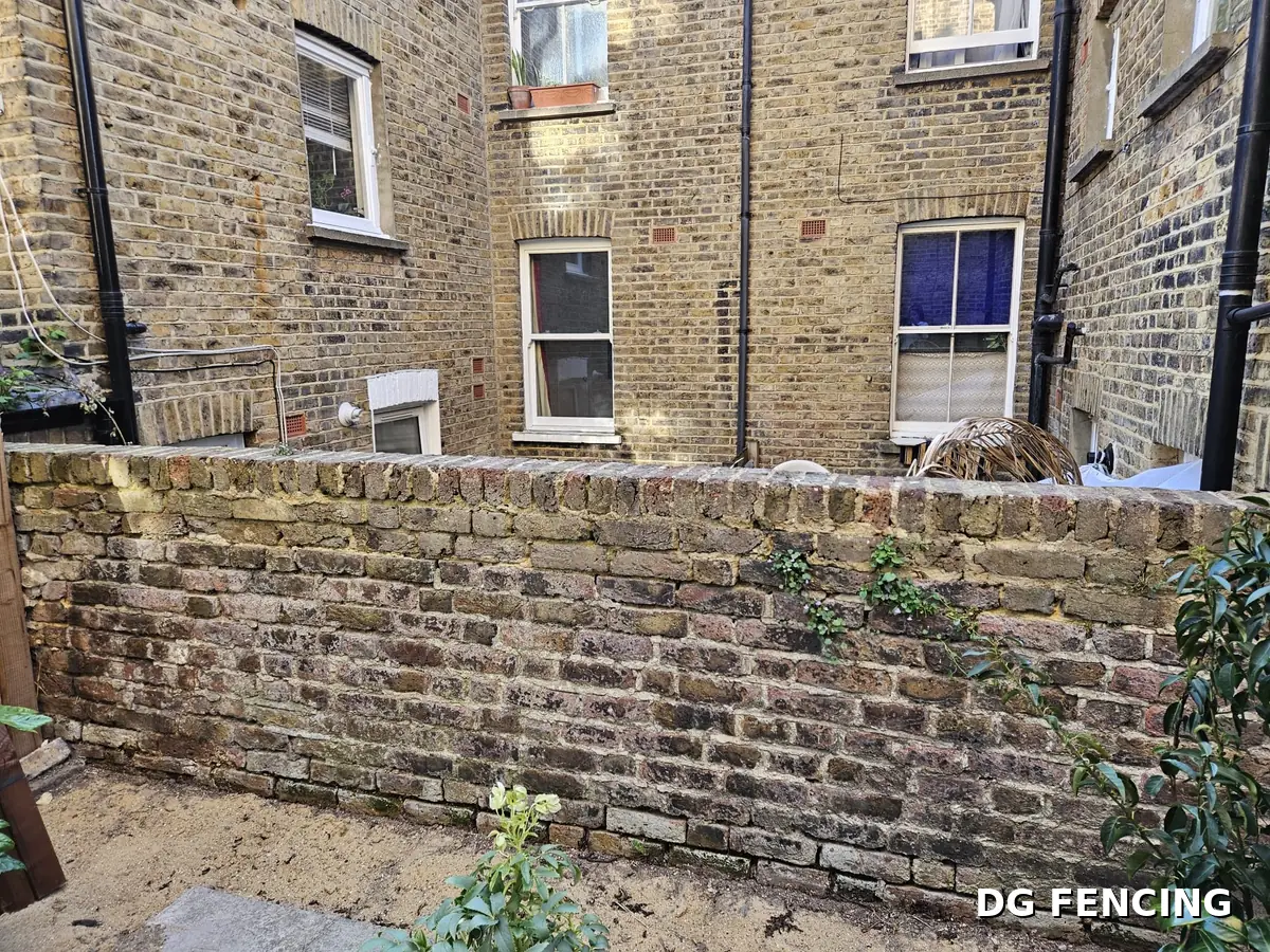 Before: the same bare brick garden wall with no screening or privacy