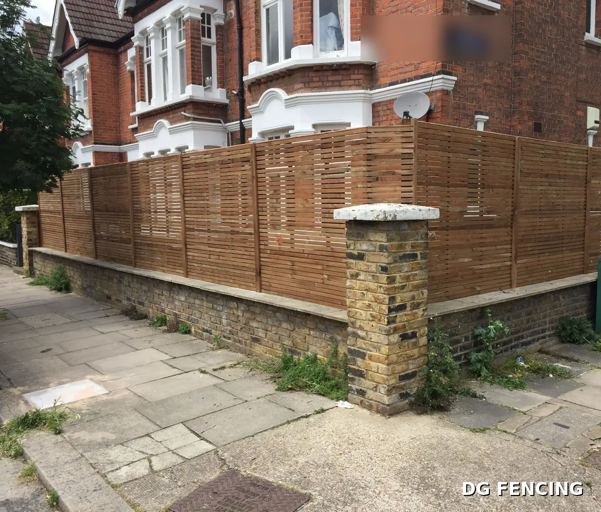 Contemporary slatted screen fencing on a brick garden wall at a street corner