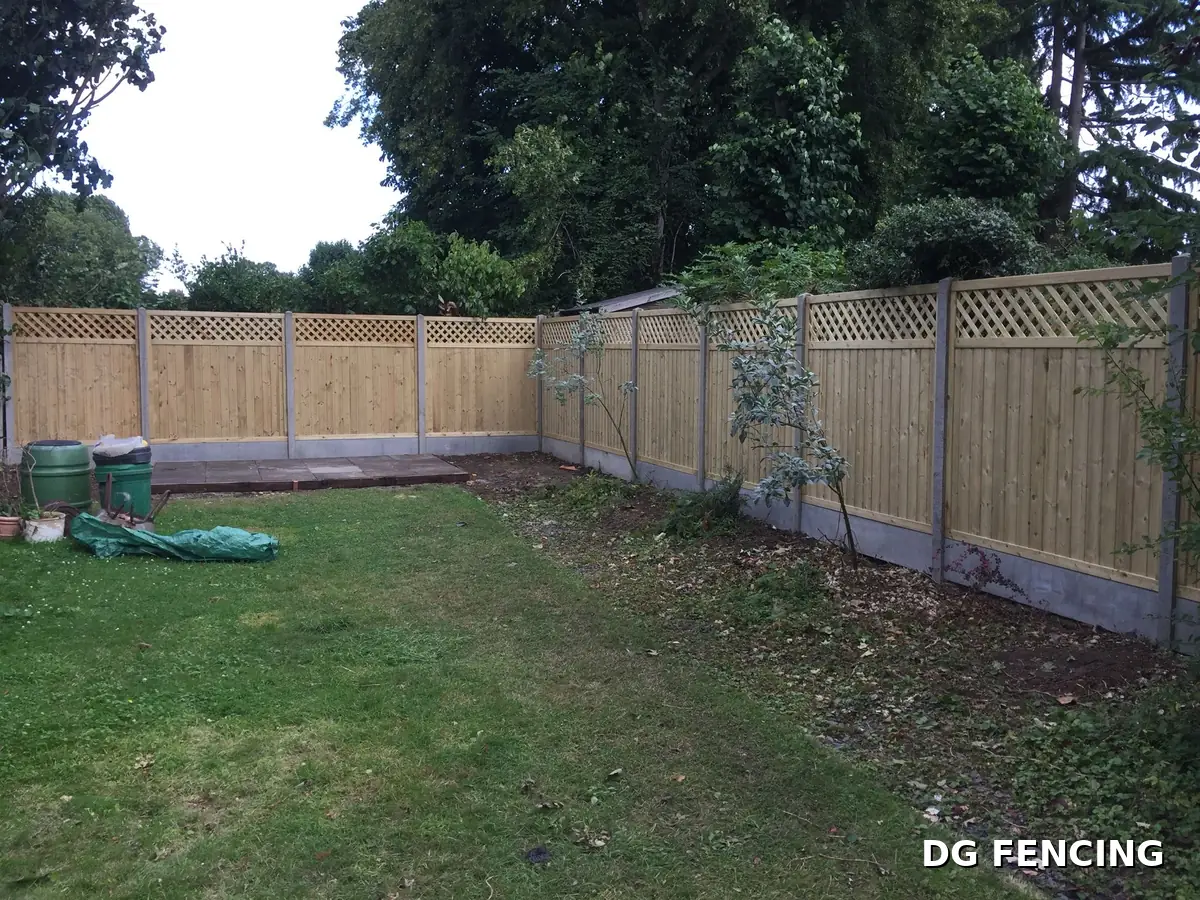 Green treated trellis-top fencing wrapping around a large garden