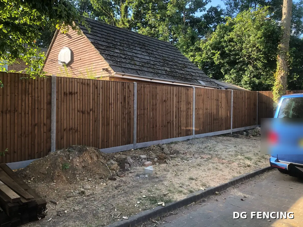 Long closeboard fence run on concrete posts alongside a driveway